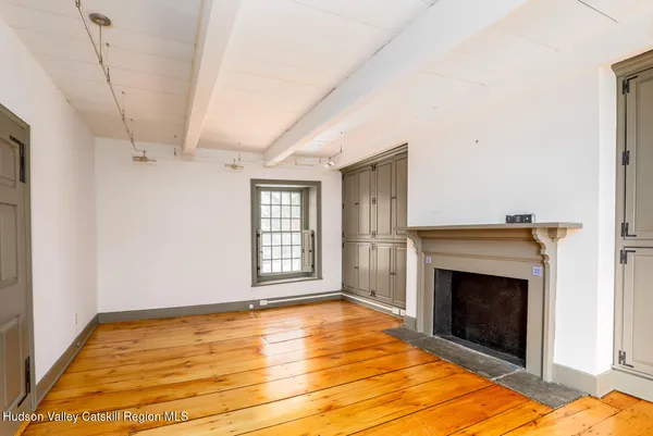 a view of empty room with a fireplace and windows