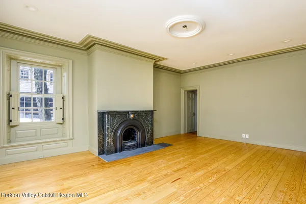 a view of empty room with a fireplace and a window