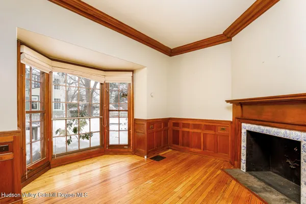 a view of an empty room with window and a fireplace