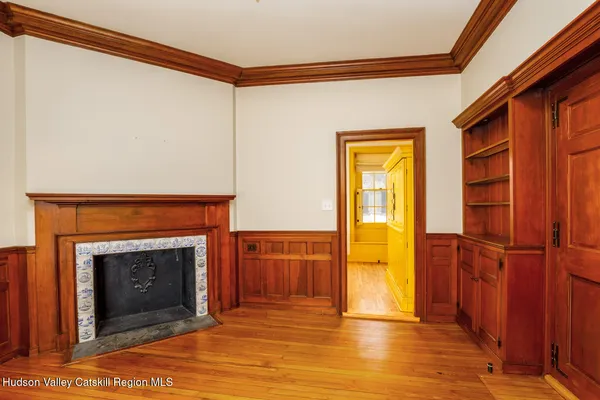 a view of an empty room with window and a fireplace