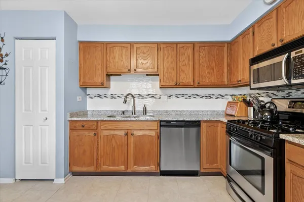 a kitchen with stainless steel appliances granite countertop a stove a sink and a microwave
