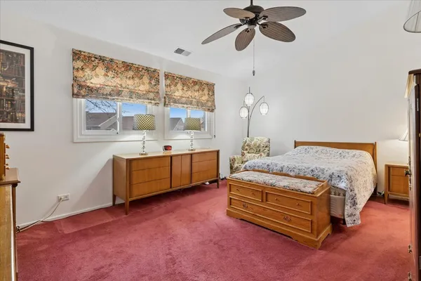 a spacious bedroom with a bed dresser and a window