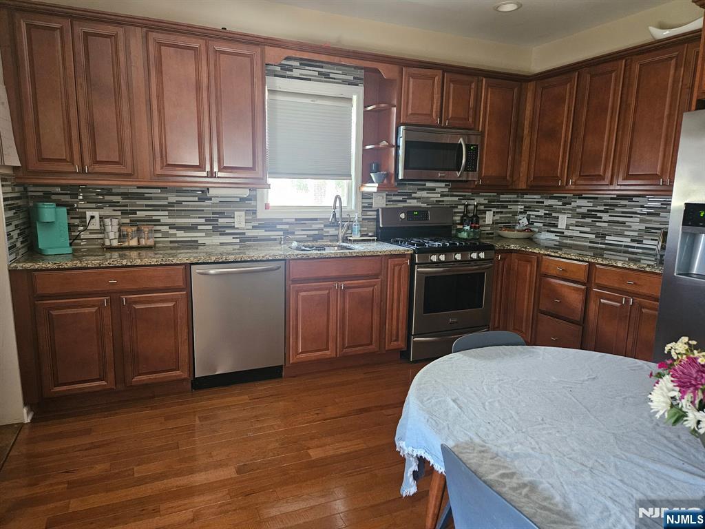 15 William Street, Unit 2 Rochelle Park, NJ 07662 - Photo 10 of 12 a kitchen with stainless steel appliances granite countertop wooden cabinets a stove top oven a sink and dishwasher