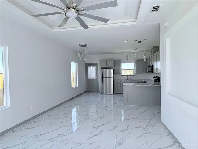 a kitchen with a sink a refrigerator and cabinets