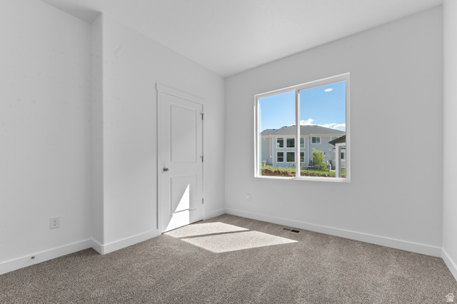 1338 West 2350 South, Unit 19 Perry, UT 84302 - Photo 11 of 14 Room featuring neutral carpeting, white walls, and bright white trim