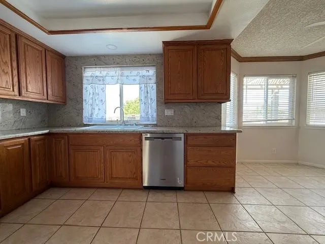 a kitchen with granite countertop a sink a stove and cabinets