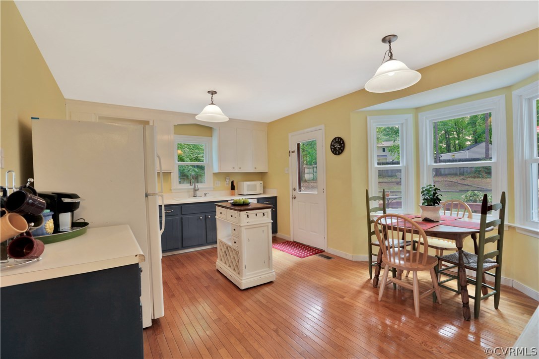 7118 Spring Trace Turn Midlothian, VA 23112 - Photo 9 of 34 a kitchen with stainless steel appliances granite countertop a stove top oven a sink a dining table and chairs with wooden floor