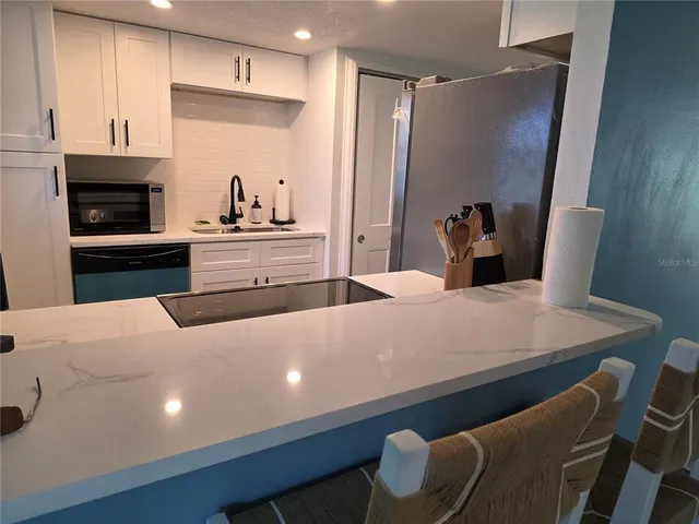 a large white kitchen with cabinets