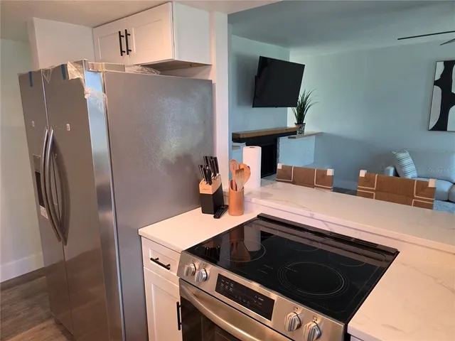 a kitchen with stainless steel appliances granite countertop a refrigerator and a stove top oven