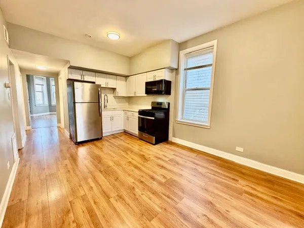 a kitchen with a refrigerator and a stove top oven