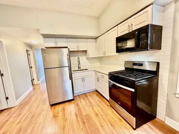 a kitchen with stainless steel appliances a refrigerator stove and microwave