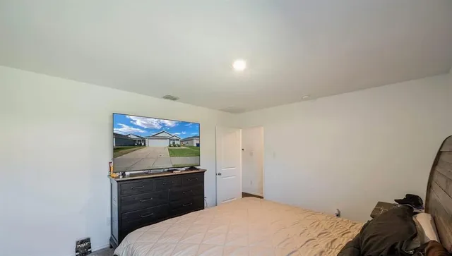 a bedroom with a bed and a flat screen tv