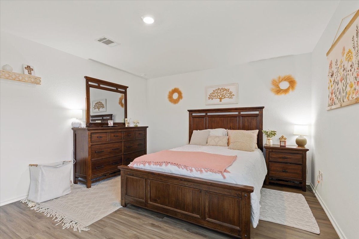 1220 Smallmouth Road Bastrop, TX 78602 - Photo 16 of 29 a bedroom with a bed and wooden floor