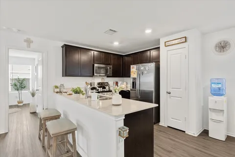 a kitchen with refrigerator cabinets and wooden floor