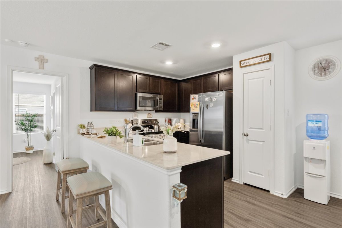 1220 Smallmouth Road Bastrop, TX 78602 - Photo 7 of 29 a kitchen with refrigerator cabinets and wooden floor