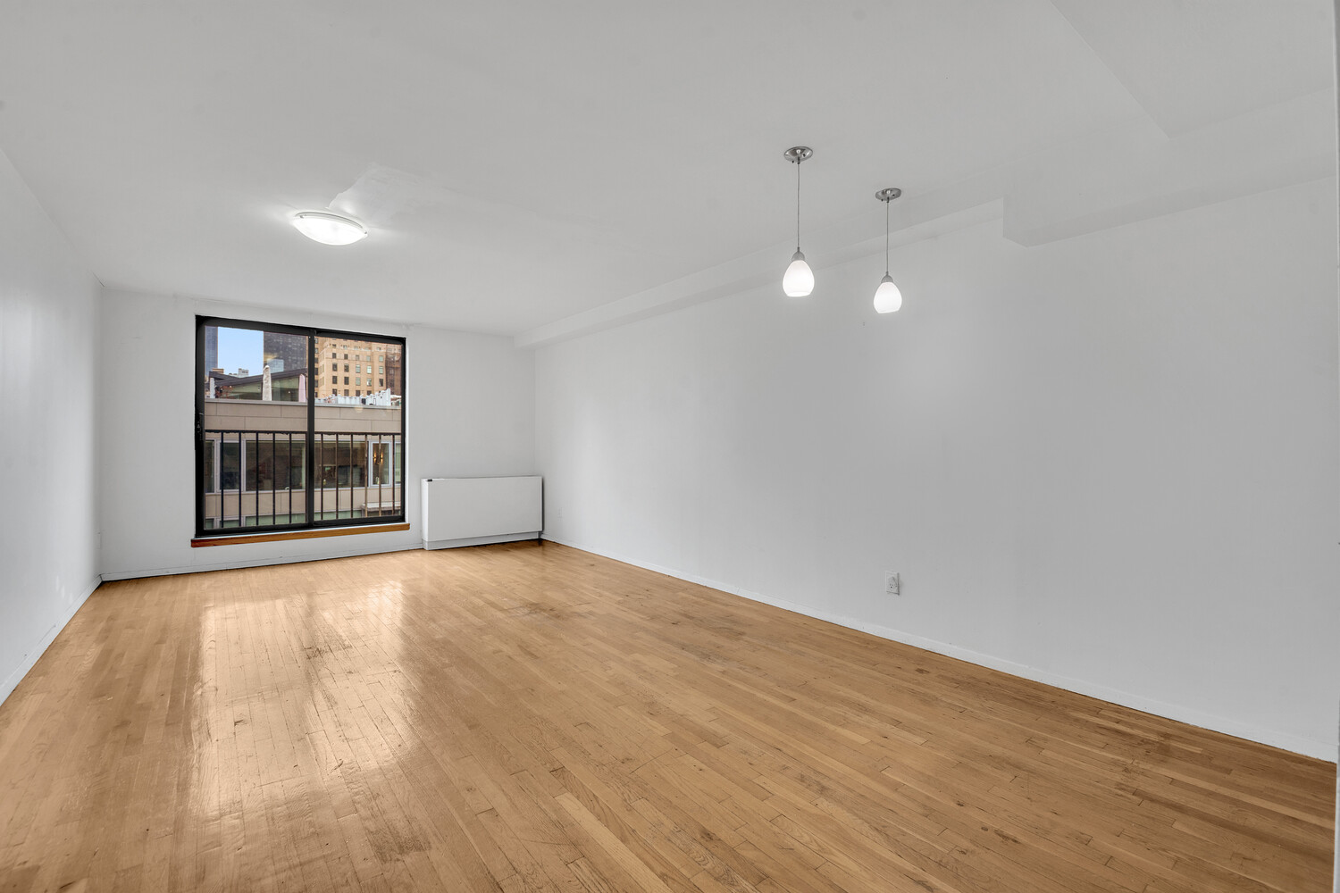 414 West 54th Street, Unit PHE Manhattan, NY 10019 - Photo 2 of 10 a view of an empty room with a window and wooden floor