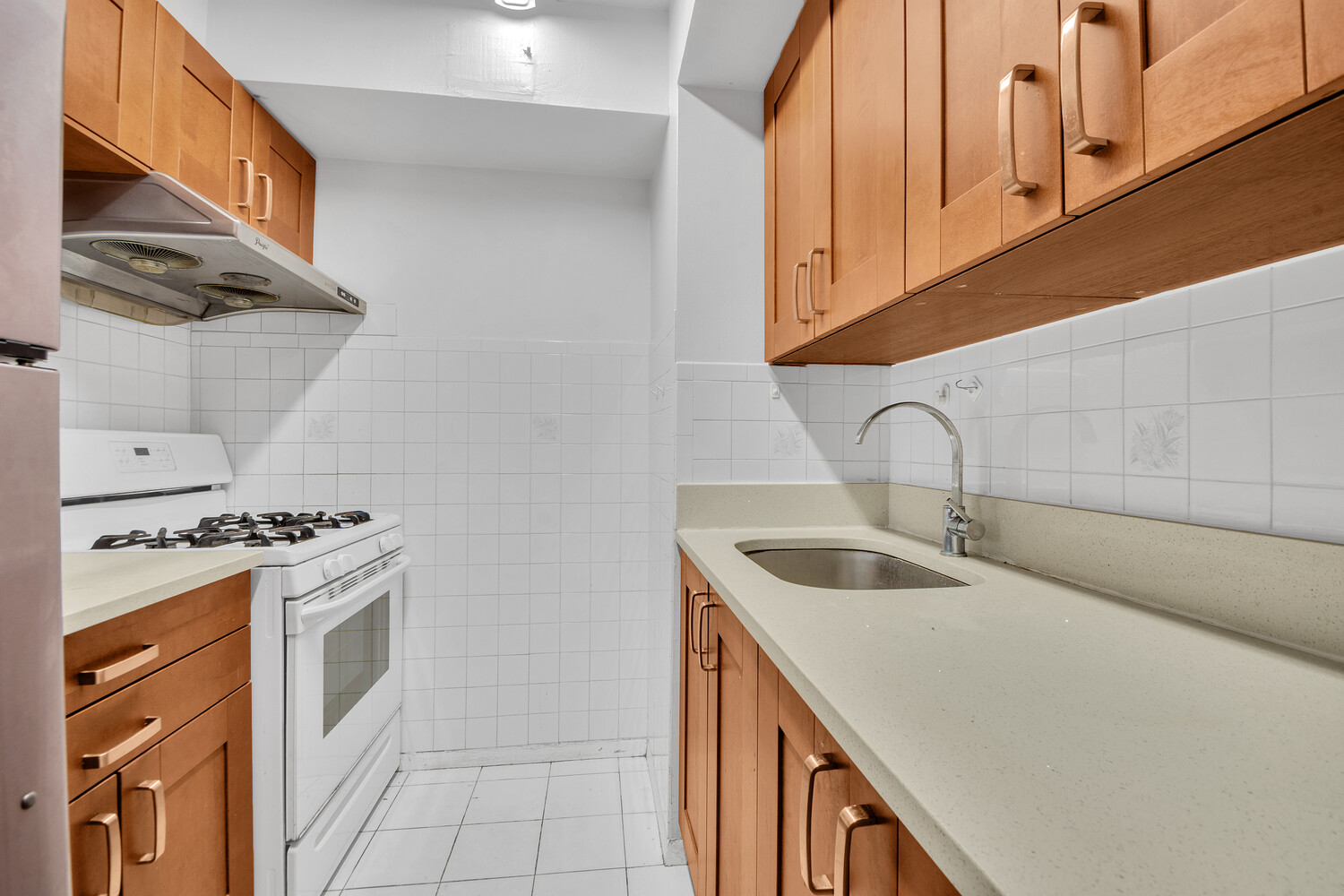 414 West 54th Street, Unit PHE Manhattan, NY 10019 - Photo 5 of 10 a kitchen with white cabinets sink and stove