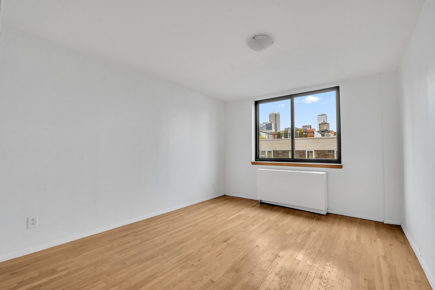 414 West 54th Street, Unit PHE Manhattan, NY 10019 - Photo 7 of 10 an empty room with wooden floor and mirror