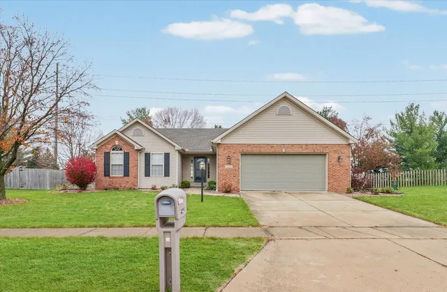 a front view of house with yard and garage