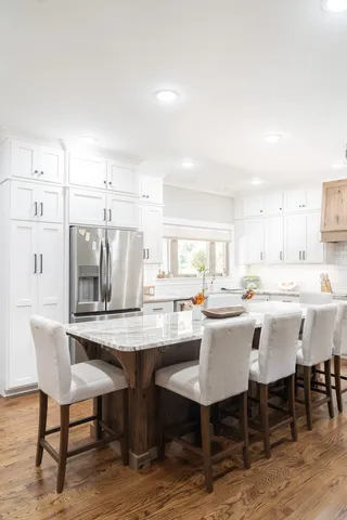 a dining hall with stainless steel appliances kitchen island granite countertop a dining table and chairs