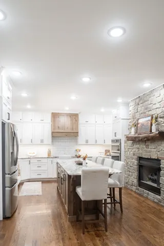a kitchen with a dining table chairs refrigerator and cabinets