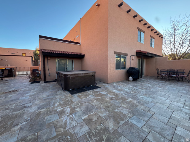 3439 Westwater Road Moab, UT 84532 - Photo 15 of 64 Back of house with a patio, stucco siding, outdoor dining space, a hot tub, and a tile roof