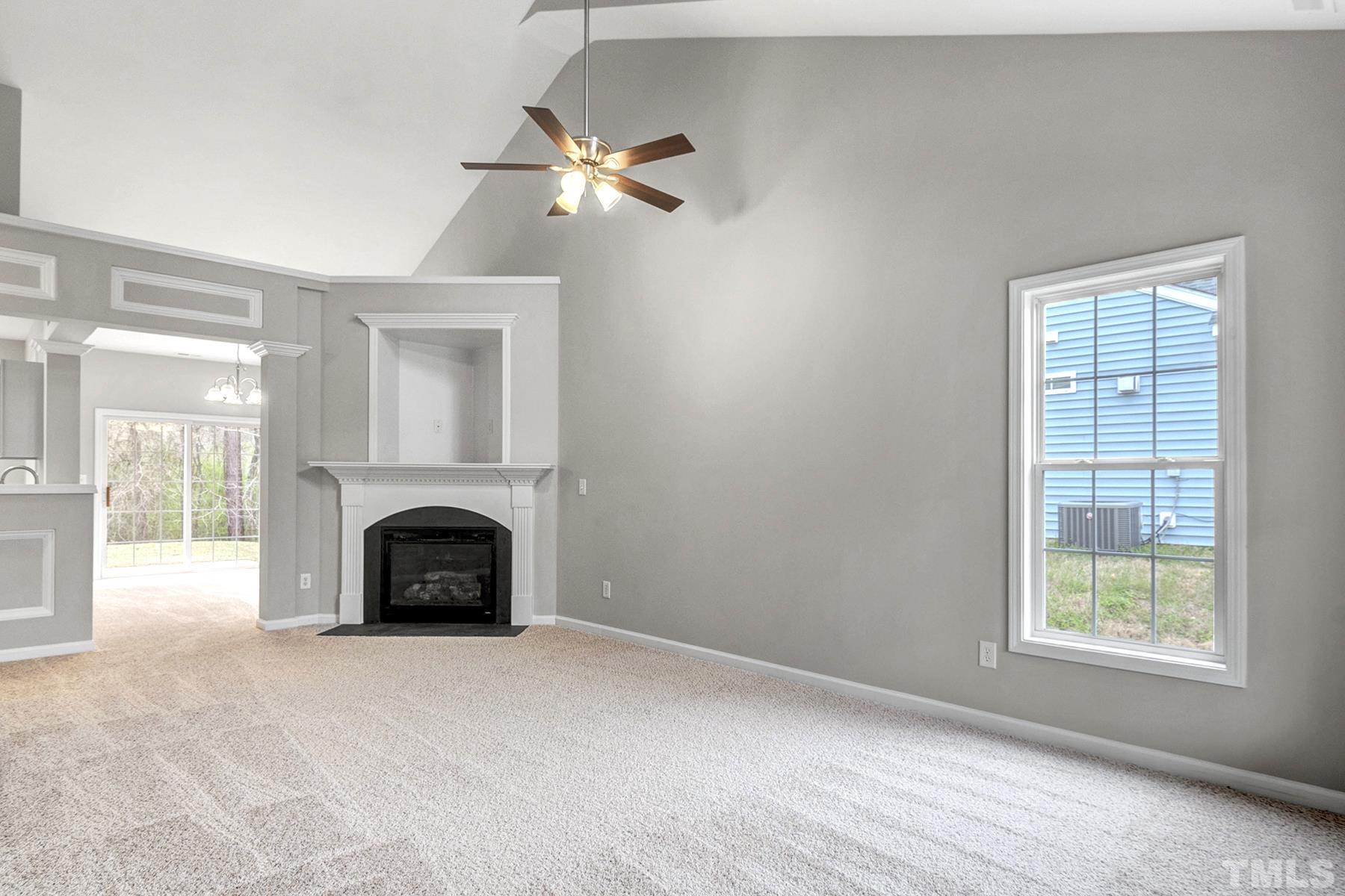 820 Nightshade Way Raleigh, NC 27610 - Photo 4 of 32 an empty room with fireplace and windows