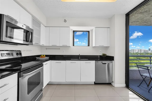 a kitchen with granite countertop a stove top oven and cabinets
