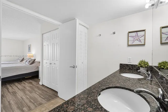 a bathroom with a granite countertop sink and a mirror