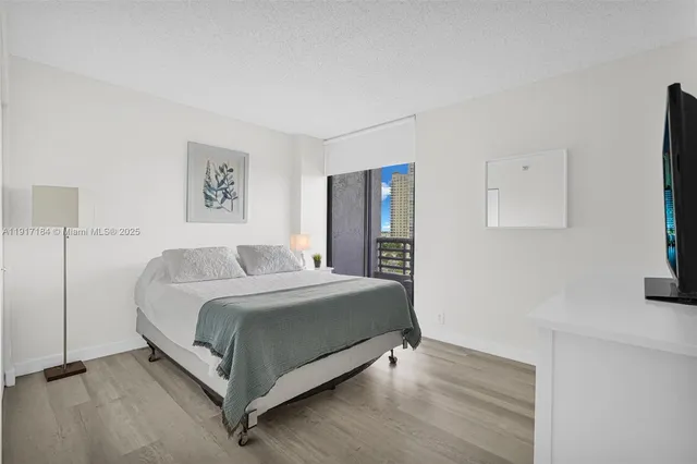 a bedroom with a bed and painting on the wall