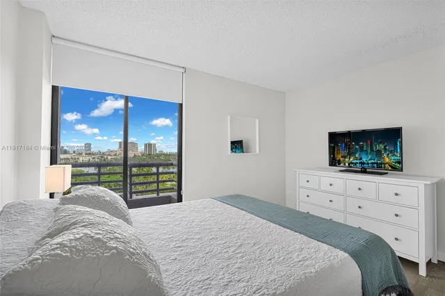a bedroom with a bed and a flat screen tv