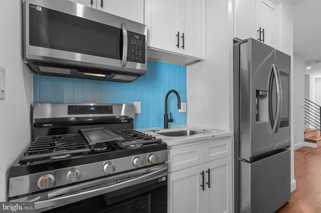 a kitchen with stainless steel appliances granite countertop a stove and a microwave
