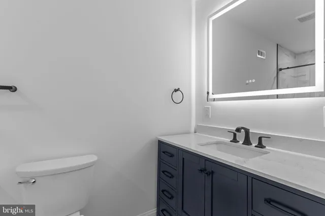 a bathroom with a sink a toilet and mirror