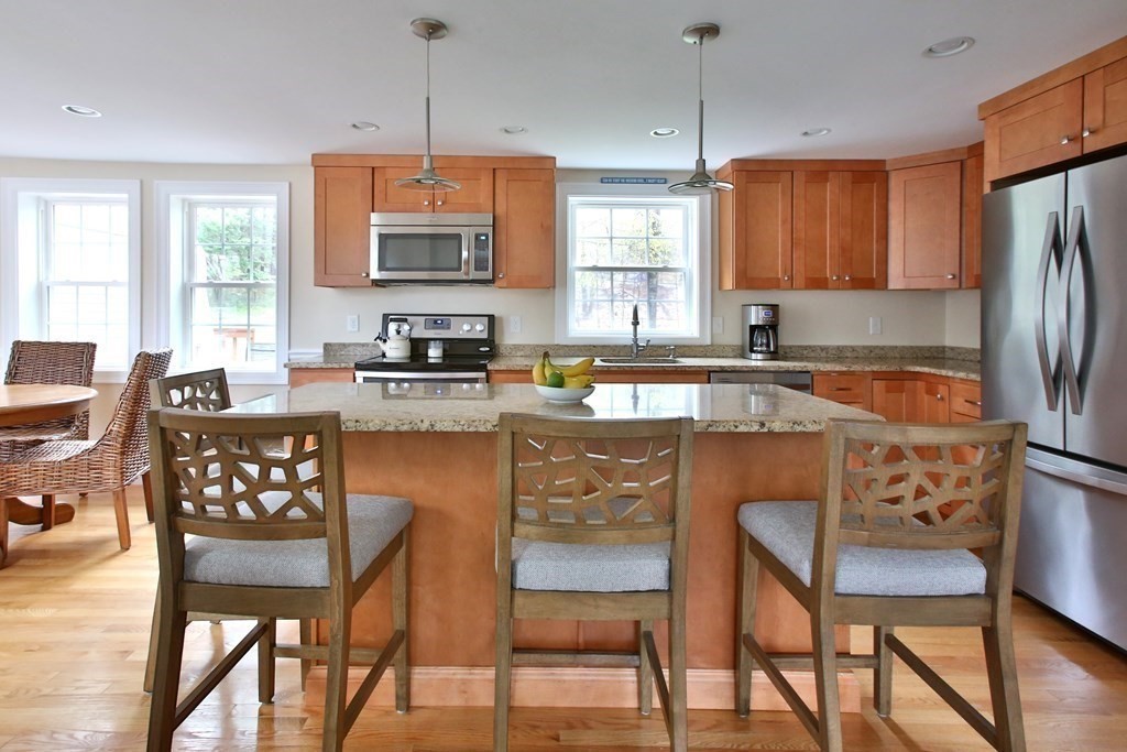 73 Moosehill Road Walpole, MA 02032 - Photo 8 of 21 a kitchen with stainless steel appliances granite countertop a dining table chairs refrigerator and sink