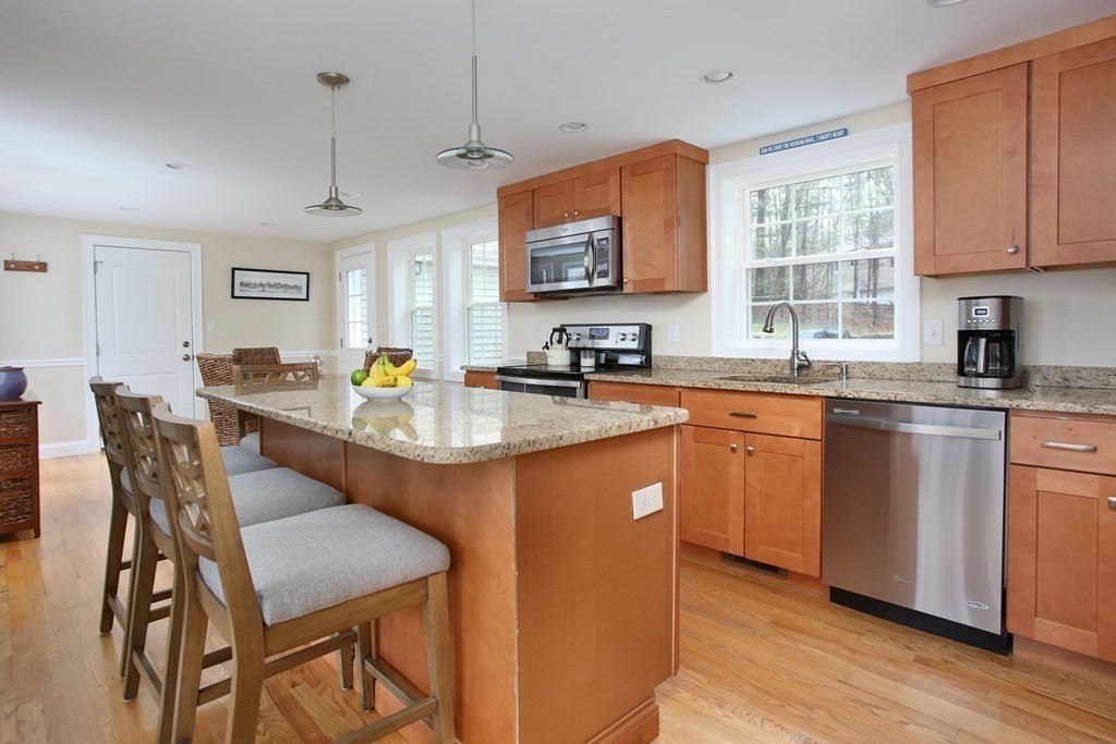 73 Moosehill Road Walpole, MA 02032 - Photo 9 of 21 a kitchen with stainless steel appliances granite countertop a kitchen island hardwood floor sink stove dining table and chairs