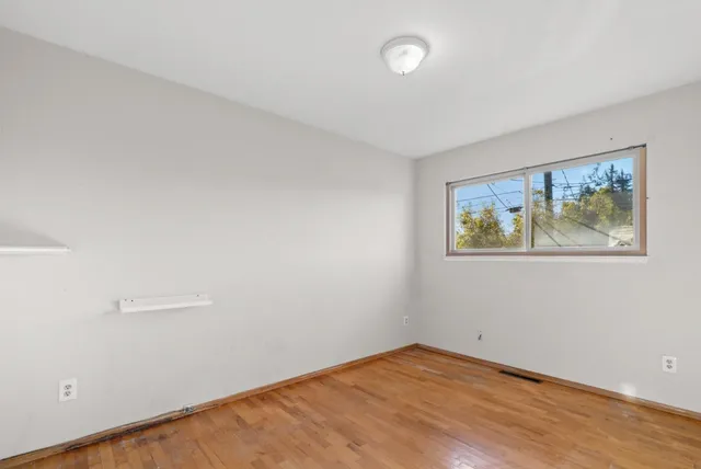 an empty room with a painting on the wall