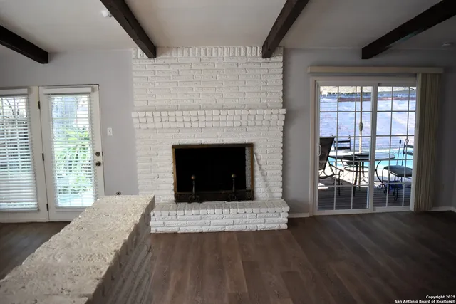 a living room with a fireplace and large windows