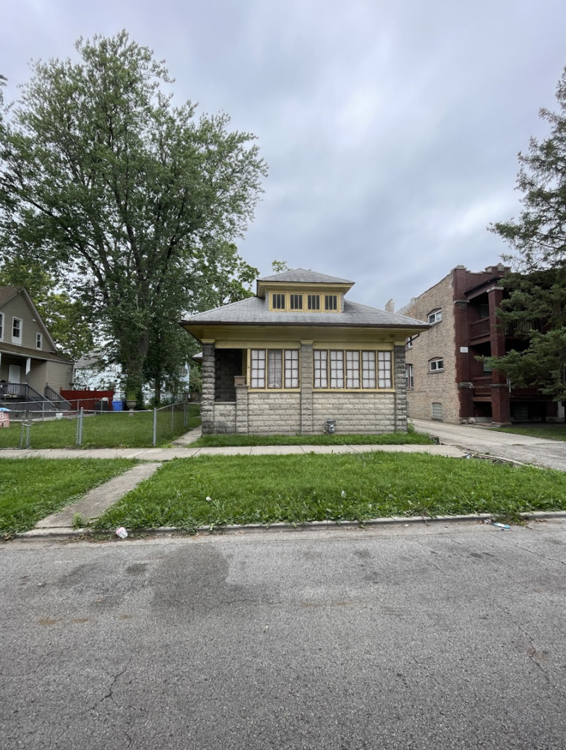 a view of a house with a yard and large trees