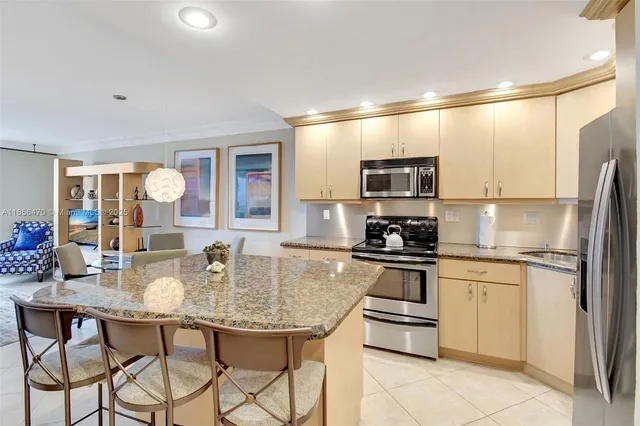 a kitchen with stainless steel appliances granite countertop a stove a sink dishwasher and a refrigerator