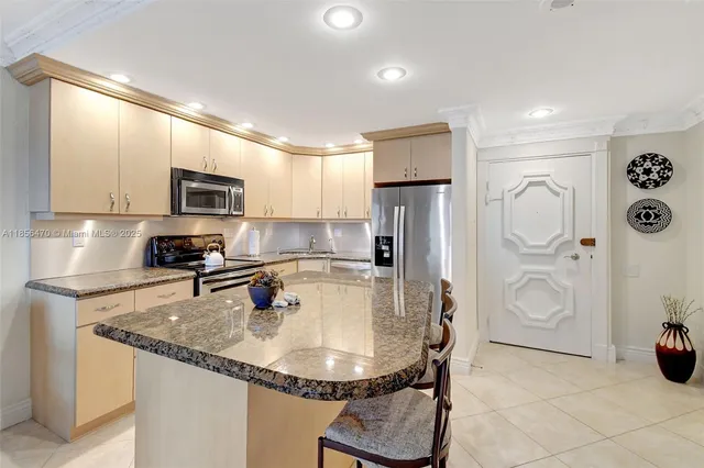 a kitchen with stainless steel appliances granite countertop a sink a refrigerator and a stove top oven