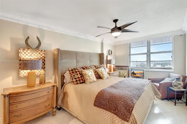 a bedroom with a large bed and a chandelier fan