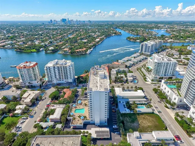 an aerial view of a city with lots of residential buildings ocean and mountain view in back