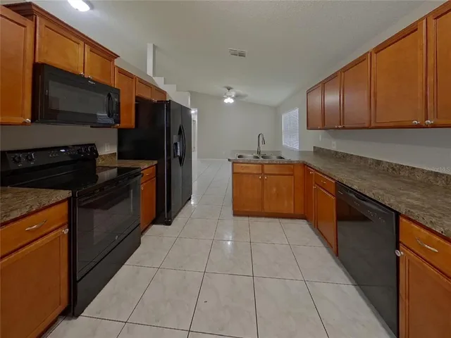 a view of an empty room and chandelier fan
