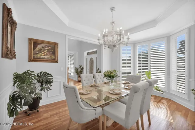 a dining room with furniture potted plants and wooden floor