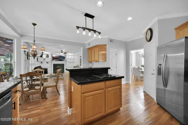 a kitchen with granite countertop a stove a refrigerator and wooden floor