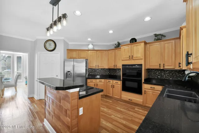 a kitchen with stainless steel appliances granite countertop a refrigerator and a stove top oven