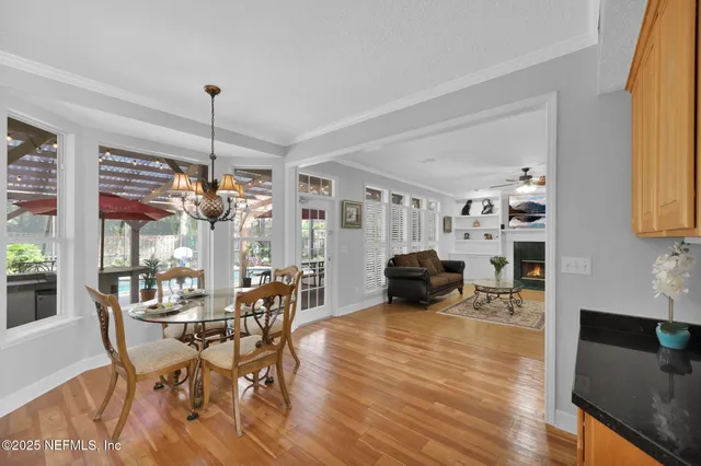 a view of a dining room with furniture a kitchen and chandelier