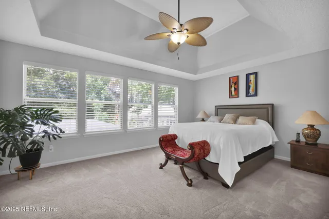 a spacious bedroom with a bed and a chandelier