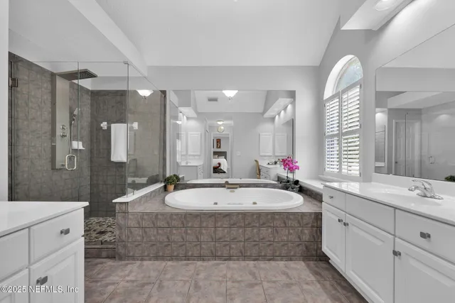 a large spacious bathroom with a tub sink and mirror