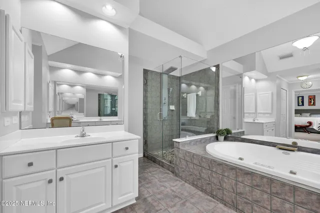 a bathroom with a granite countertop double vanity sink a mirror and a shower